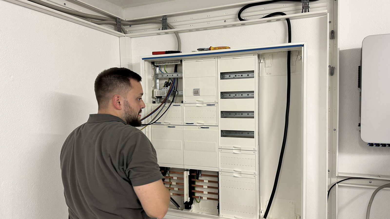 Neu gesetzter Zählerschrank mit offener Tür, Sammelschienen, Reihenklemmen und Platz für Zähler und Smart Meter